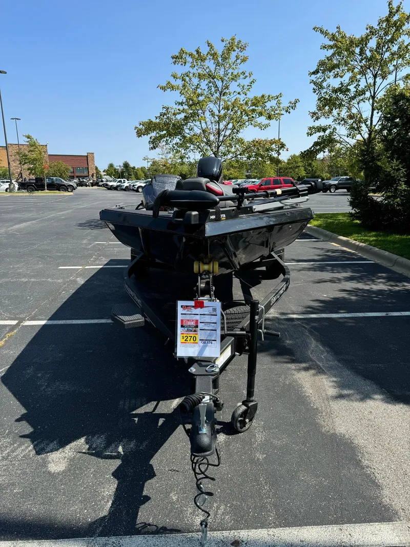 Slide: The Image of 2024 Ranger RT178C boat parked in a lot, viewed from the front. - 2