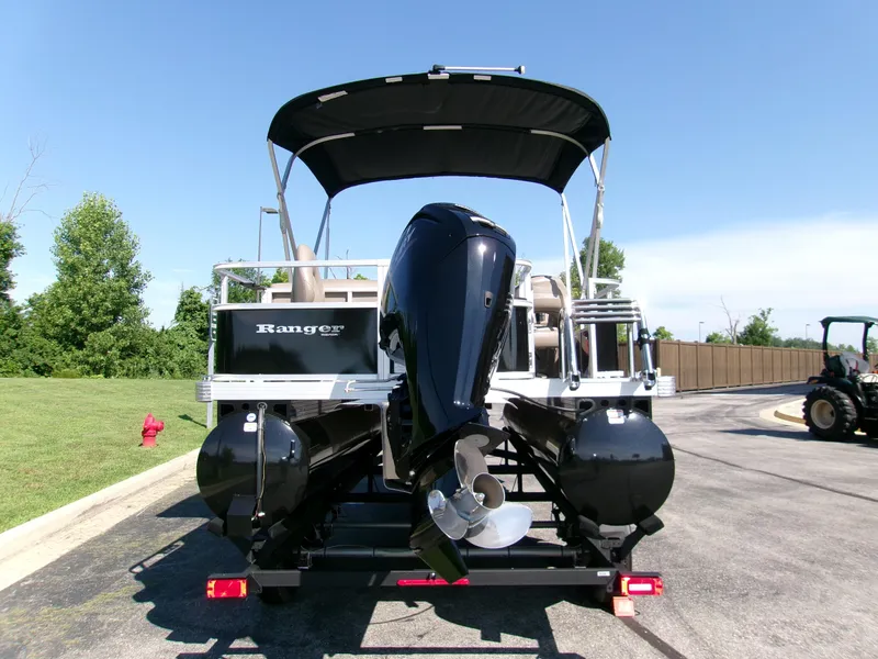 Slide: The Image of 2024 Ranger Reata 200F pontoon boat with outboard motor, parked on a sunny day. - 2