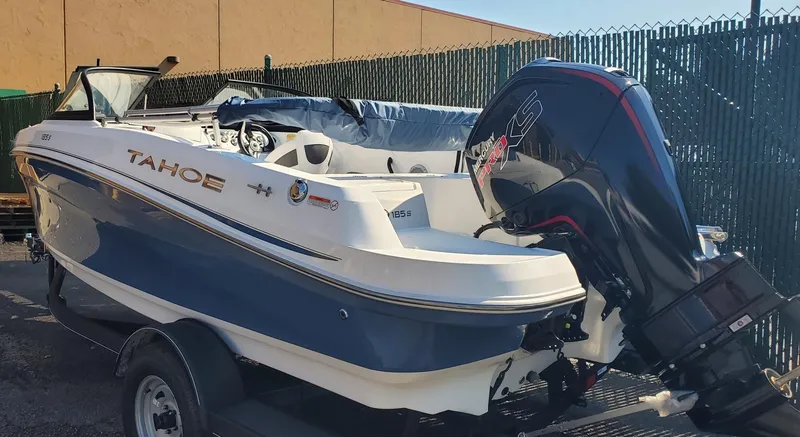 Slide: The Image of 2024 Tahoe 185 S boat with outboard motor, parked on a trailer. - 2