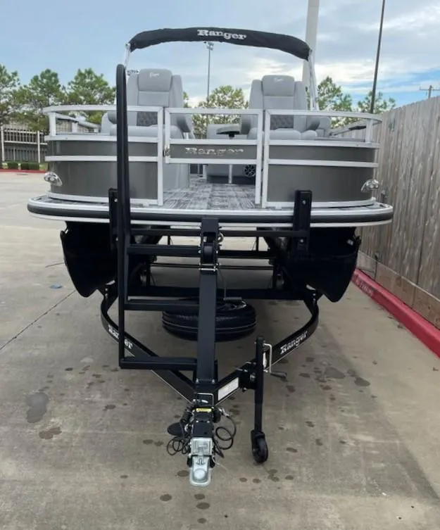 Slide: The Image of 2024 Ranger Reata 220F pontoon boat on trailer, parked outdoors. - 3