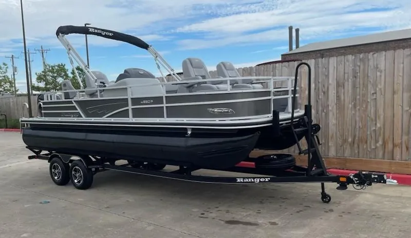 Slide: The Image of 2024 Ranger Reata 220F pontoon boat on trailer, parked outdoors. - 4