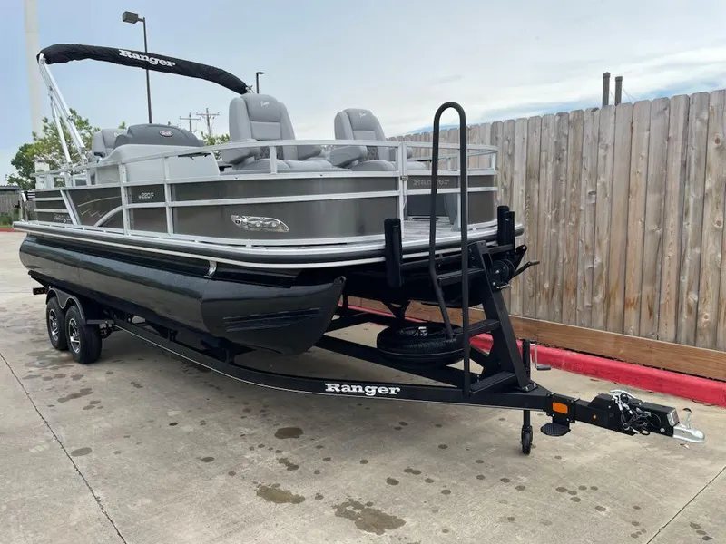 Slide: The Image of 2024 Ranger Reata 220F pontoon boat on trailer, parked outdoors. - 3