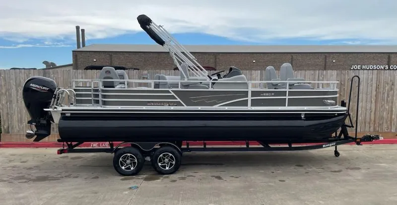 Slide: The Image of 2024 Ranger Reata 220F pontoon boat on trailer, parked outdoors. - 5