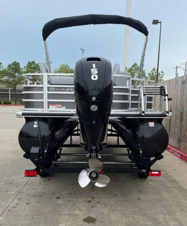 Slide: The Image of 2024 Ranger Reata 220F pontoon boat with 150 HP engine, parked outdoors. - 6