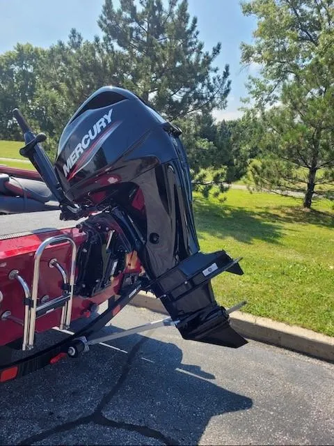 Slide: The Image of 2024 Ranger VS1665T boat with Mercury outboard motor in a sunny park setting. - 2