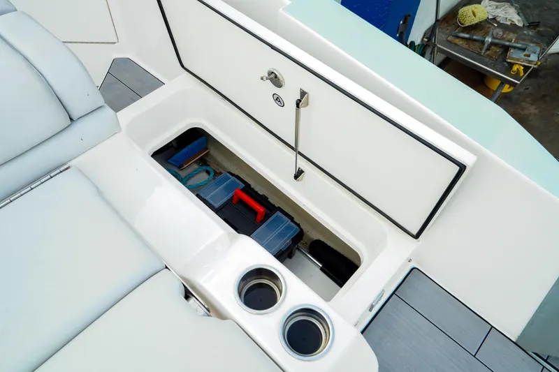 Slide: The Image of 2022 Aviara AV32 OB boat storage compartment with cup holders and organized gear. - 18