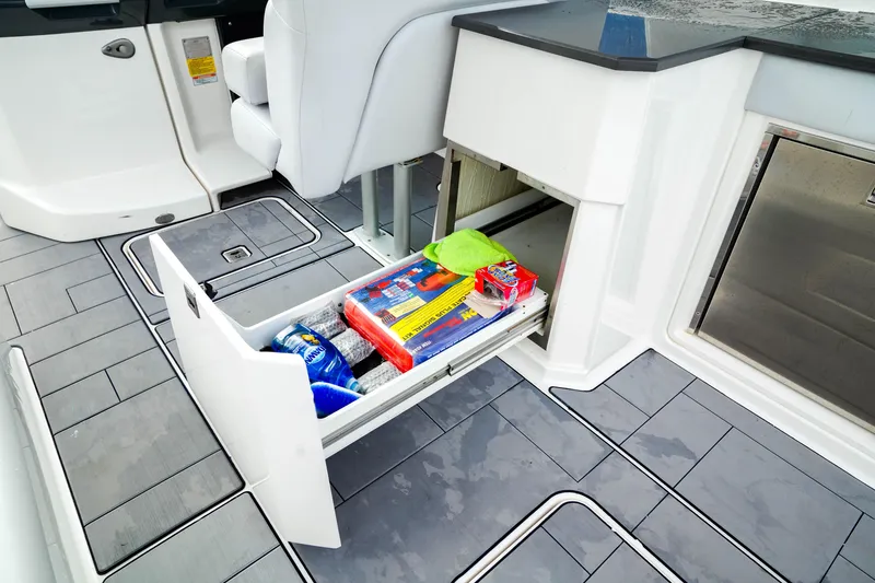 Slide: The Image of 2022 Aviara AV32 OB boat interior with open storage drawer, showcasing organized supplies. - 23