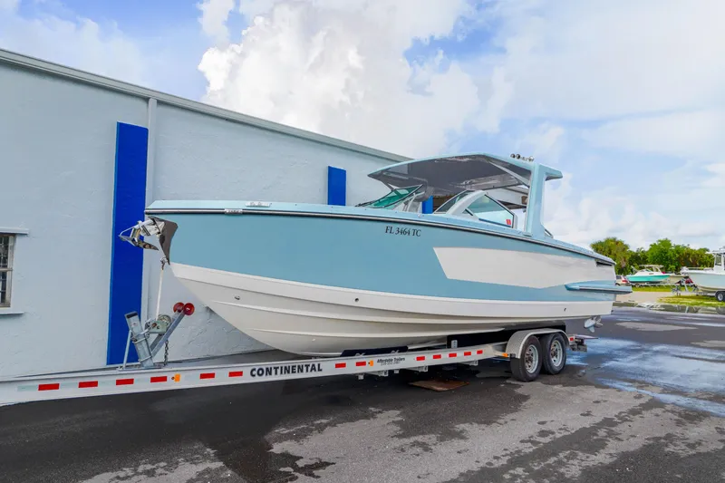 Slide: The Image of 2022 Aviara AV32 OB boat on trailer, light blue and white, parked outdoors. - 48