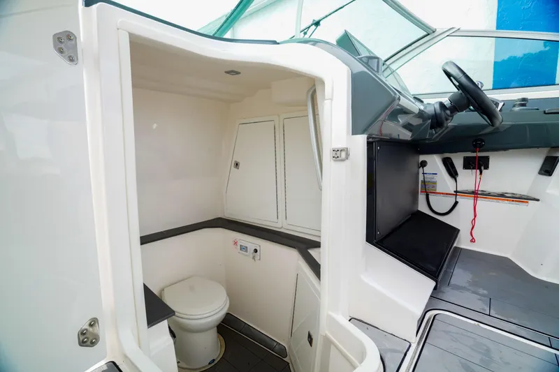 Slide: The Image of 2022 Aviara AV32 OB boat interior with compact bathroom and helm station. - 5