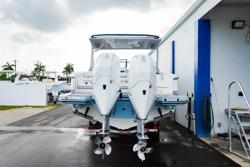 Slide: The Image of 2022 Aviara AV32 OB boat with dual outboard engines, parked near a building. - 9