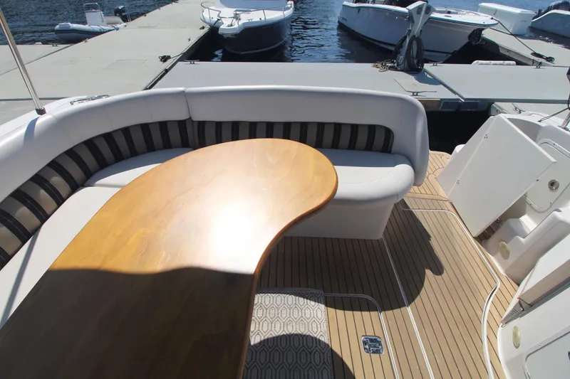 Slide: The Image of 2006 Four Winns 378 Vista boat with curved seating and wooden table on deck. - 15