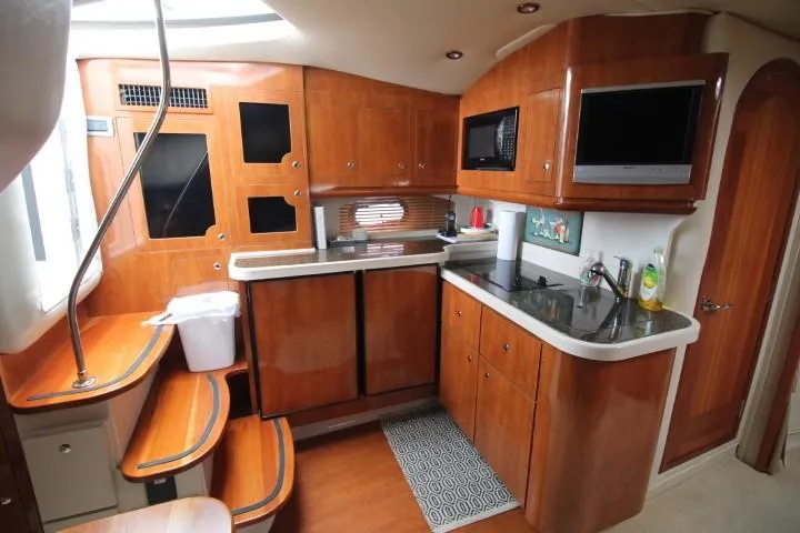 Slide: The Image of 2006 Four Winns 378 Vista yacht interior with wooden cabinetry and modern kitchen amenities. - 24