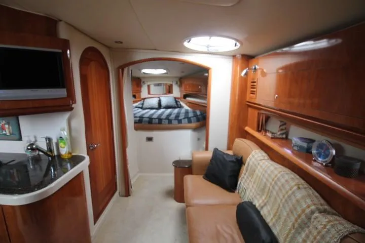 Slide: The Image of Interior of 2006 Four Winns 378 Vista yacht, featuring cozy seating and elegant wood finishes. - 26