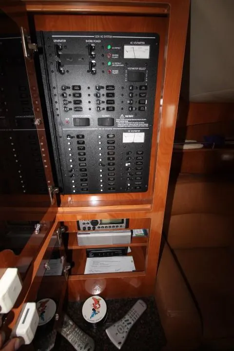 Slide: The Image of Electrical panel inside 2006 Four Winns 378 Vista yacht with remote controls and storage shelves. - 46