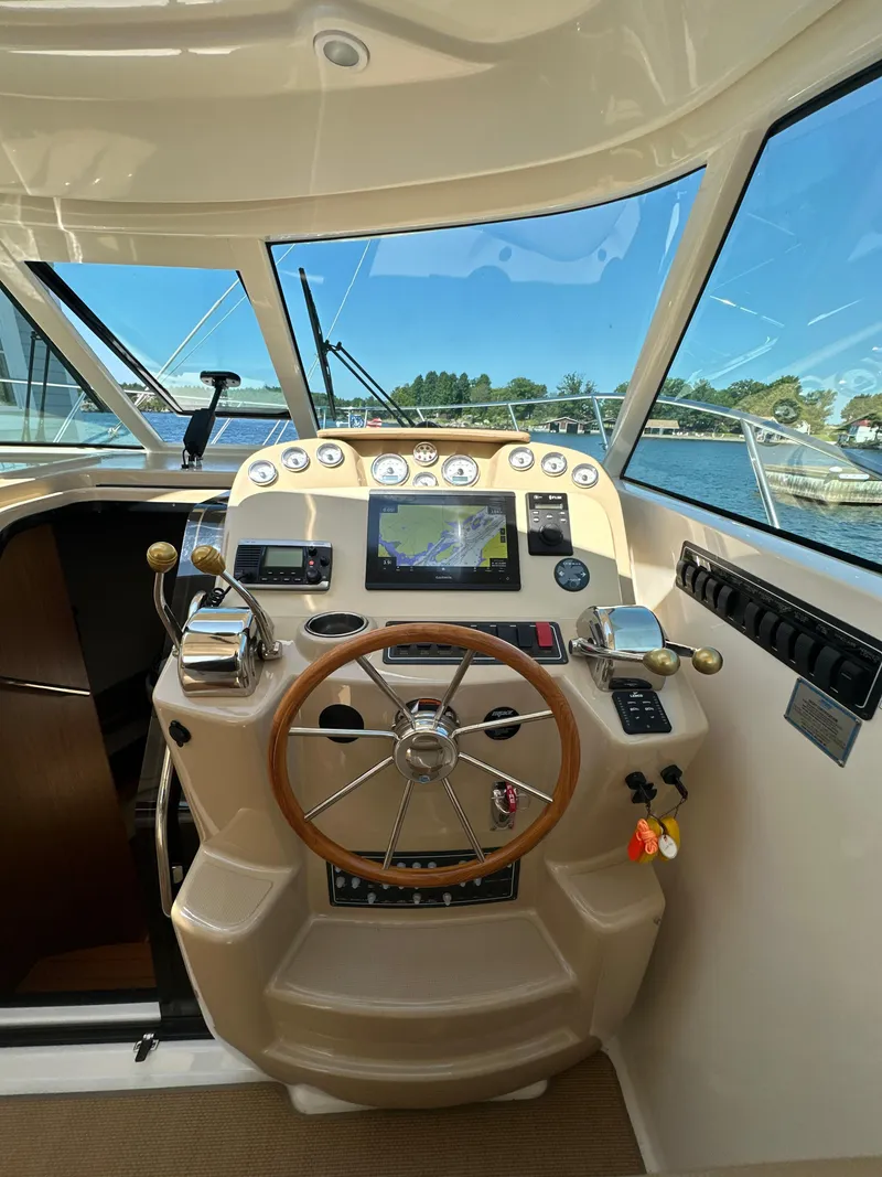 Slide: The Image of 2014 Tiara Yachts 3100 Coronet helm with steering wheel and navigation controls. - 16