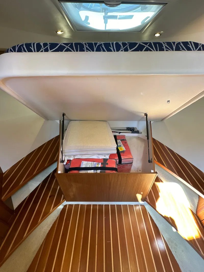 Slide: The Image of 2014 Tiara Yachts 3100 Coronet interior with under-bed storage and wooden flooring. - 18