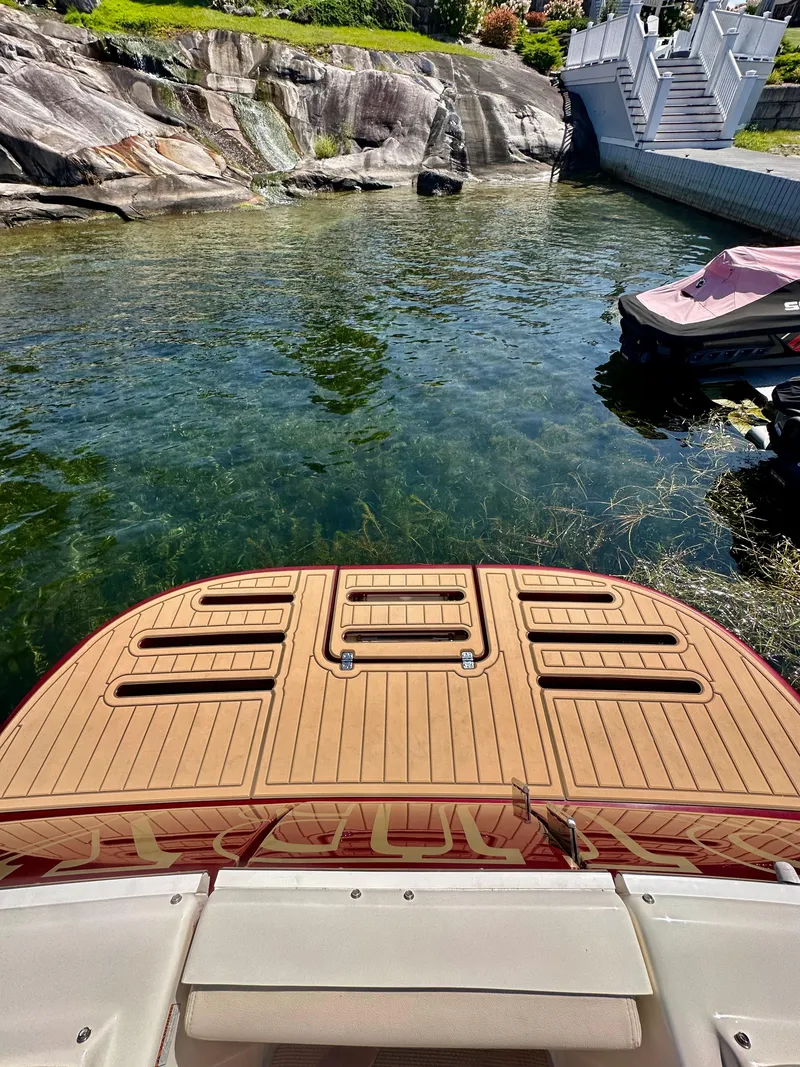 Slide: The Image of 2014 Tiara Yachts 3100 Coronet with teak deck near rocky shoreline. - 4