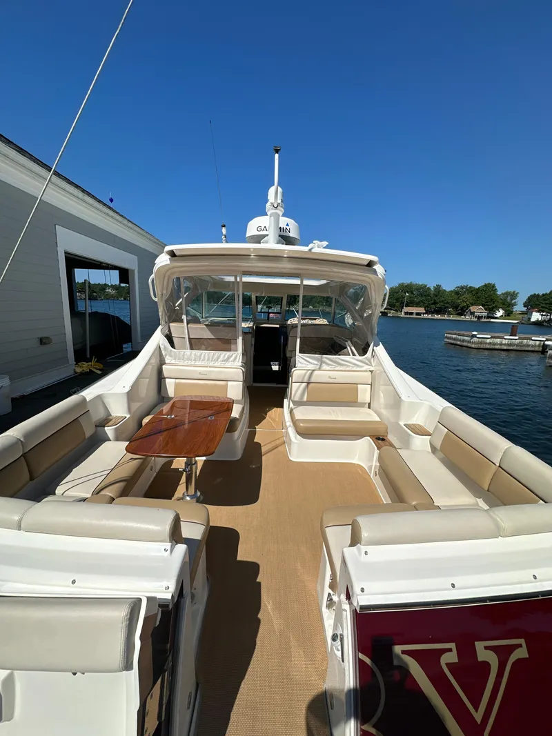 Slide: The Image of 2014 Tiara Yachts 3100 Coronet with spacious deck and seating, docked by the water. - 5
