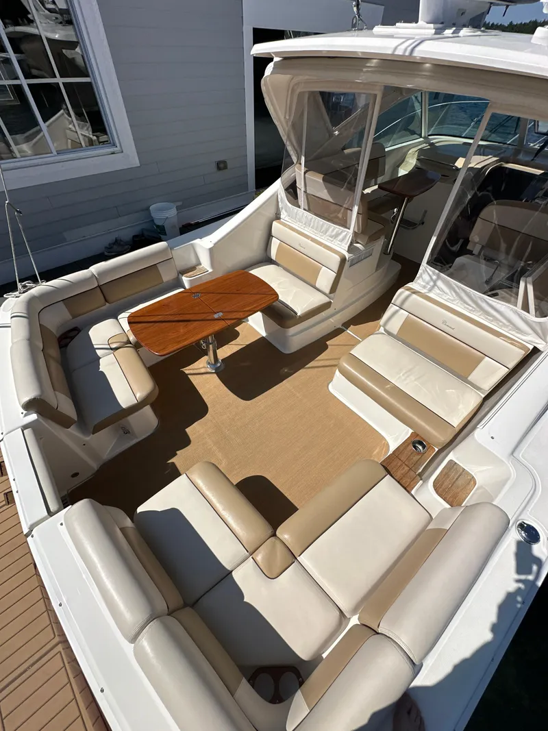 Slide: The Image of 2014 Tiara Yachts 3100 Coronet with spacious seating and wooden table on deck. - 6