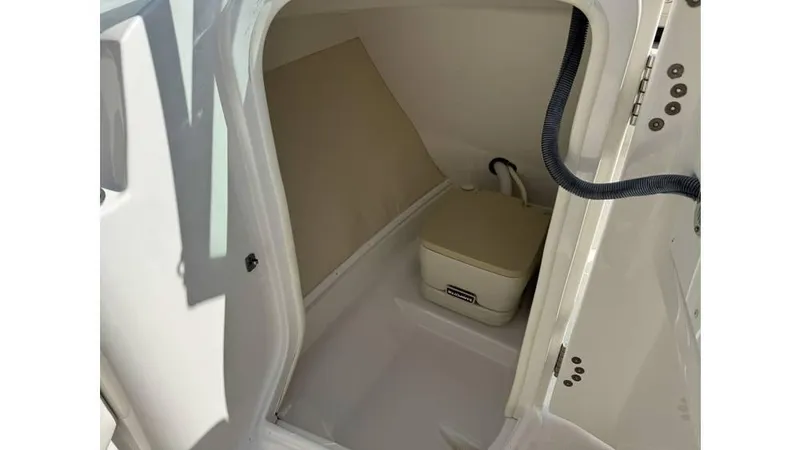 Slide: The Image of 2007 Monterey 234FS boat interior with compact toilet and storage space. - 2