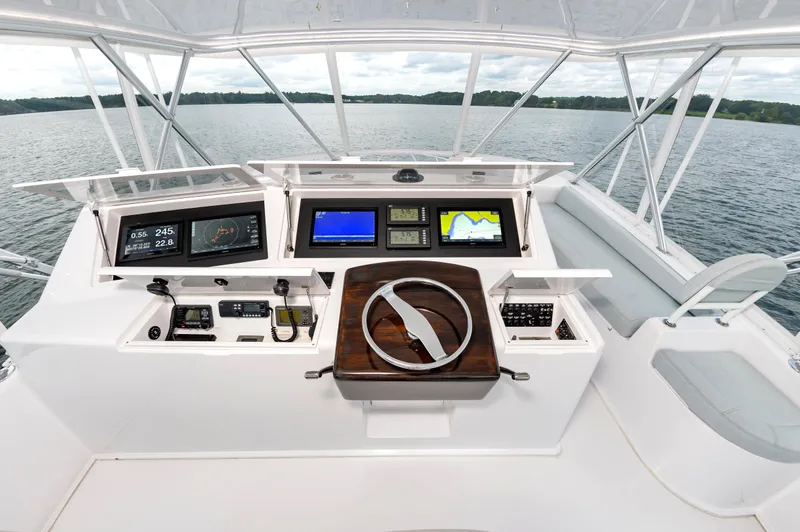 Slide: The Image of 2003 Viking 61 Convertible yacht helm with advanced navigation displays on a serene lake. - 10