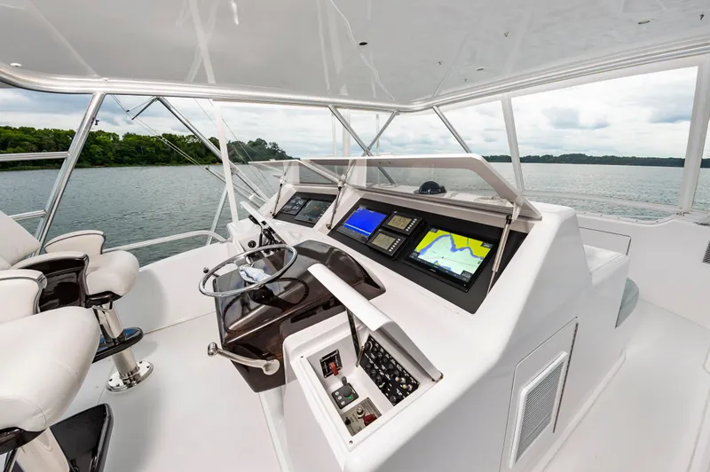 Slide: The Image of 2003 Viking 61 Convertible yacht helm with navigation screens and steering wheel. - 13
