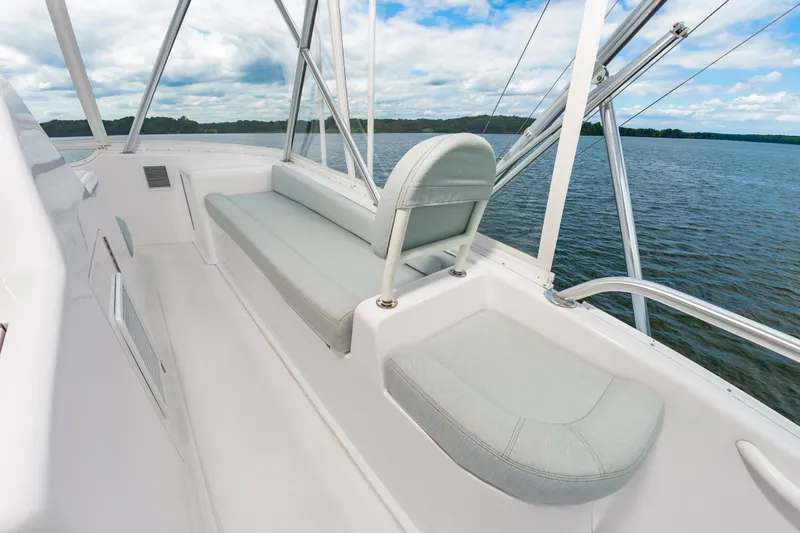 Slide: The Image of 2003 Viking 61 Convertible yacht interior with seating, overlooking calm waters and blue sky. - 19