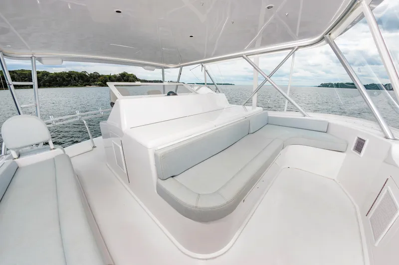 Slide: The Image of Luxurious seating area on a 2003 Viking 61 Convertible yacht, overlooking serene waters. - 21