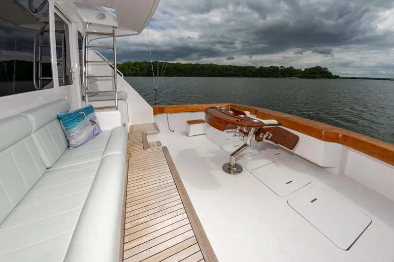 Slide: The Image of 2003 Viking 61 Convertible yacht deck with seating and fishing chair, overlooking calm waters. - 26