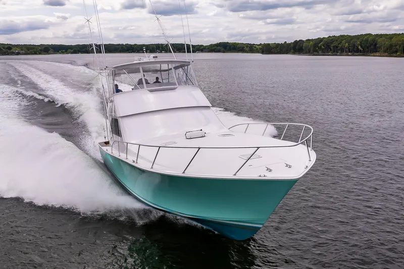 Slide: The Image of 2003 Viking 61 Convertible yacht cruising on a scenic lake. - 3