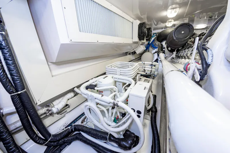 Slide: The Image of Engine room of 2003 Viking 61 Convertible yacht, showcasing complex machinery and piping. - 37