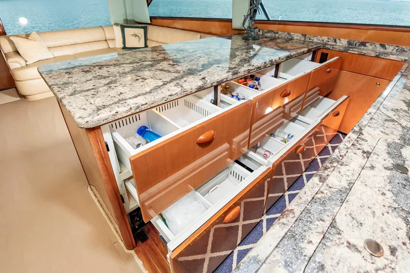 Slide: The Image of Luxurious 2003 Viking 61 Convertible yacht interior with open kitchen drawers and granite countertops. - 47