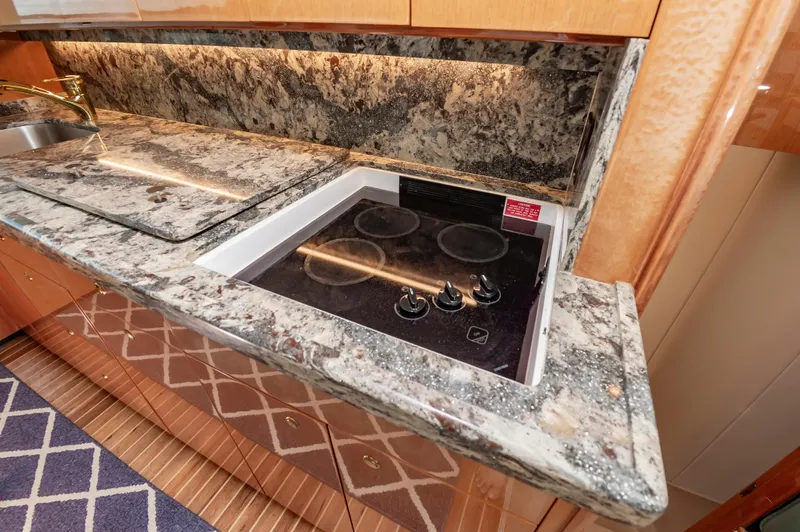 Slide: The Image of Luxurious kitchen in 2003 Viking 61 Convertible yacht with granite countertops and electric stove. - 49