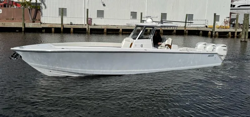 Slide: The Image of 2025 Jupiter 380LS boat on water, sleek design, triple engines, dockside view. - 2