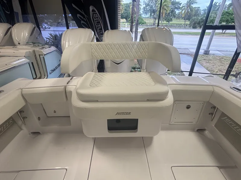 Slide: The Image of 2025 Jupiter 380LS boat interior with white seating and storage compartments. - 21