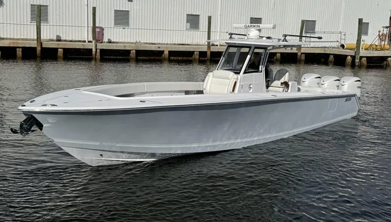Slide: The Image of 2025 Jupiter 380LS boat on water, sleek design, triple engines, dockside view. - 3