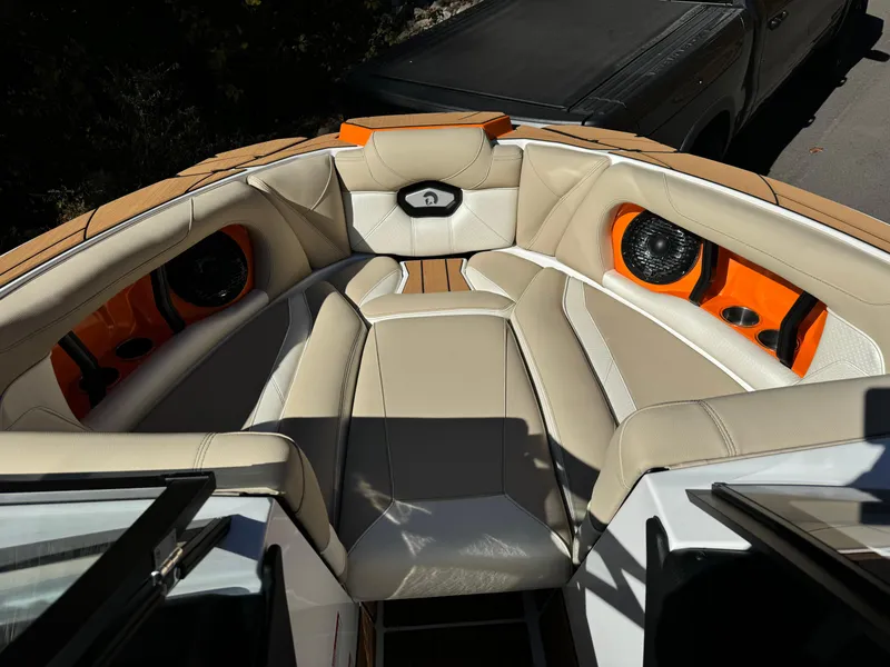 Slide: The Image of 2023 Centurion Ri230 boat interior with beige and orange seating, featuring built-in speakers. - 16