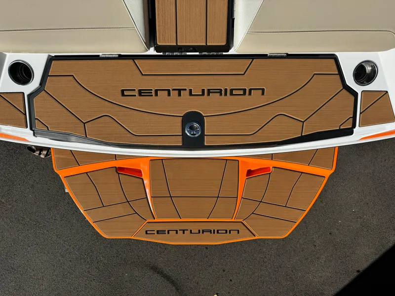 Slide: The Image of 2023 Centurion Ri230 boat deck with wood finish and orange accents. - 18