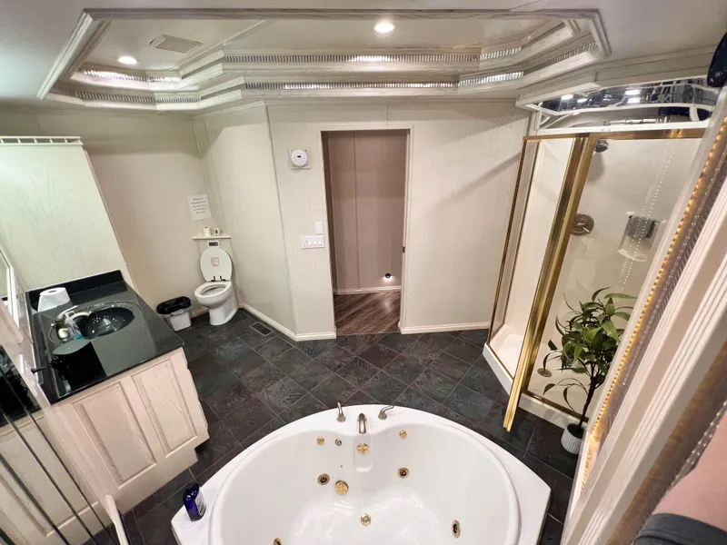 Slide: The Image of Luxurious bathroom with jacuzzi, shower, and modern fixtures in a Thoroughbred 99 x 20 model. - 16