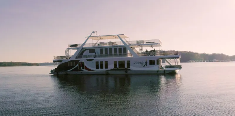 Slide: The Image of Thoroughbred 99 x 20 houseboat on calm lake, 2002 model, under clear sky. - 2
