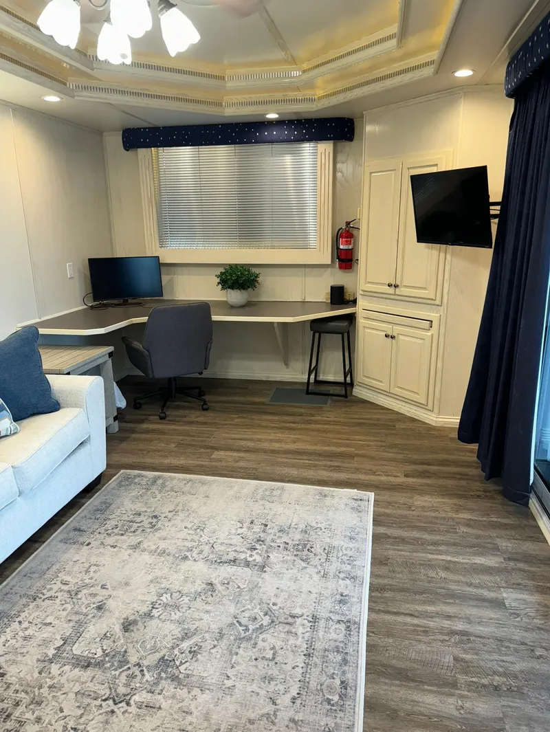 Slide: The Image of Modern RV interior with desk, TV, and sofa, featuring wood flooring and elegant lighting. - 24