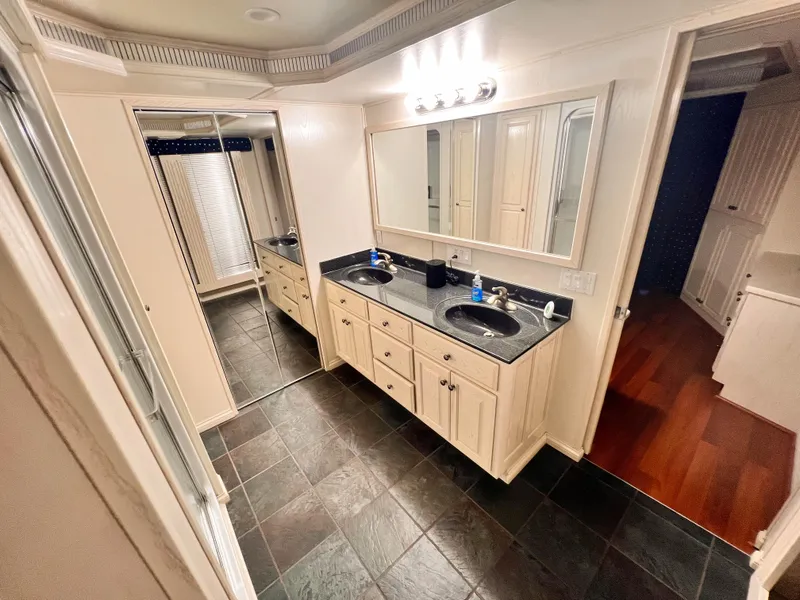 Slide: The Image of Spacious bathroom with dual sinks, large mirrors, and slate flooring. - 28