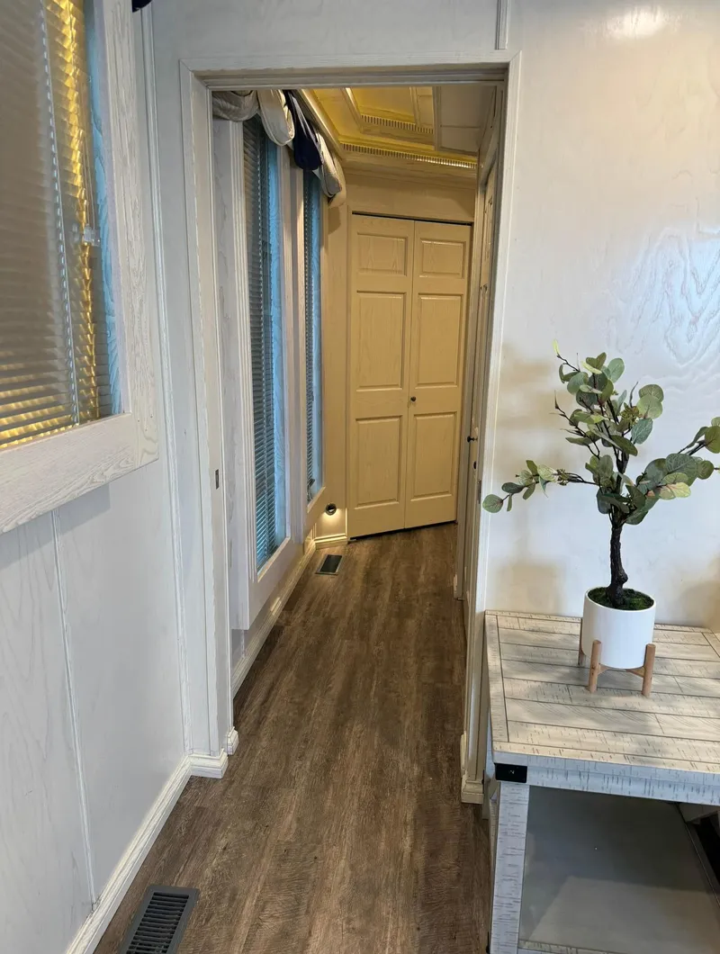 Slide: The Image of Hallway in 2002 Thoroughbred 99 x 20 model, featuring wood flooring and potted plant decor. - 33