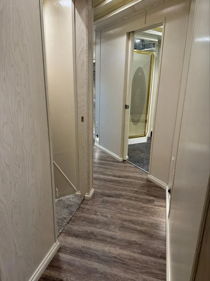 Slide: The Image of Narrow hallway with wood flooring and mirrored doors in a Thoroughbred 99 x 20, 2002 model. - 34
