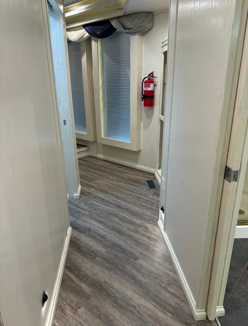Slide: The Image of Hallway in 2002 Thoroughbred 99 x 20 model with wood flooring and fire extinguisher. - 35