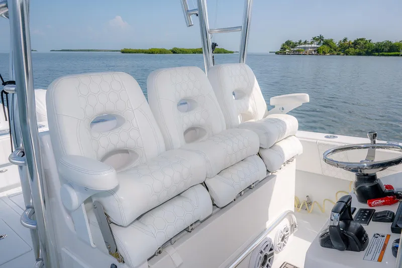 Slide: The Image of 2022 Contender 39 ST boat with luxurious white seating, steering console, and scenic water view. - 10