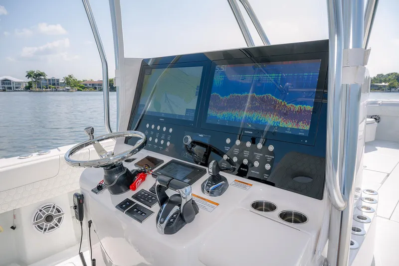 Slide: The Image of 2022 Contender 39 ST boat dashboard with advanced navigation screens and controls. - 11
