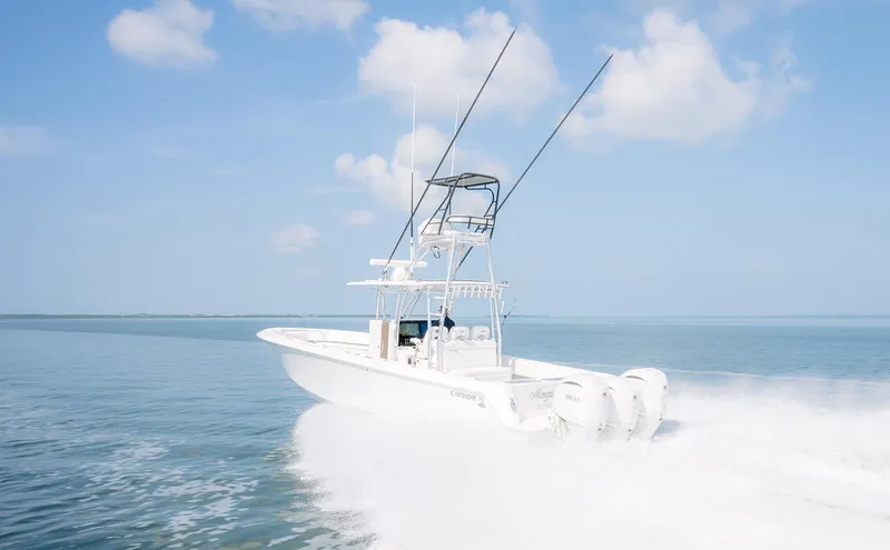 Slide: The Image of 2022 Contender 39 ST boat cruising on a lake with lush greenery in the background. - 23