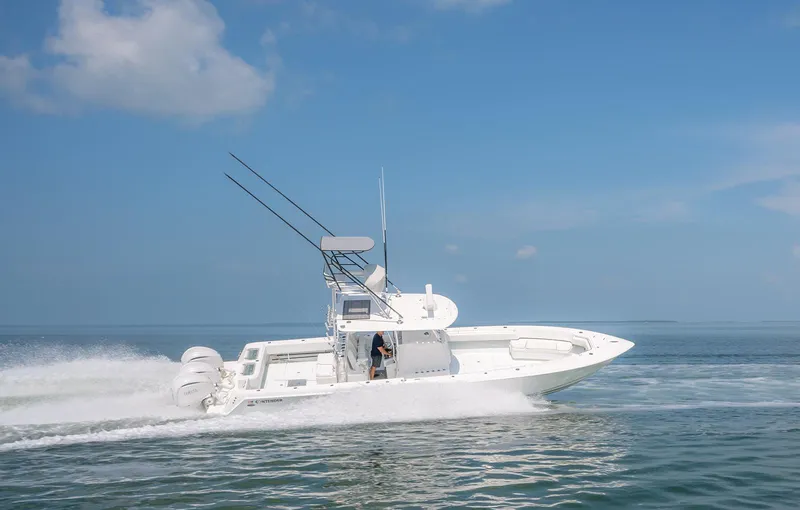 Slide: The Image of 2022 Contender 39 ST boat speeding on open water under clear blue sky. - 27