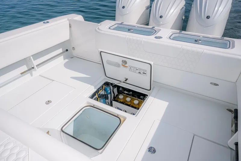 Slide: The Image of 2022 Contender 39 ST boat deck with open storage compartments and triple engines. - 8